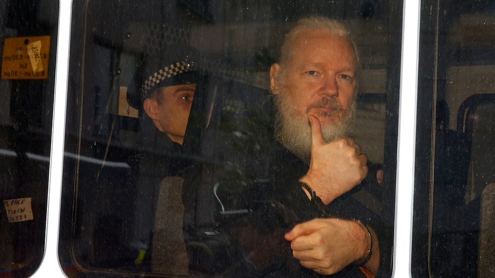 Julian Assange i en polisbil efter att han gripits av brittisk polis under torsdagen.