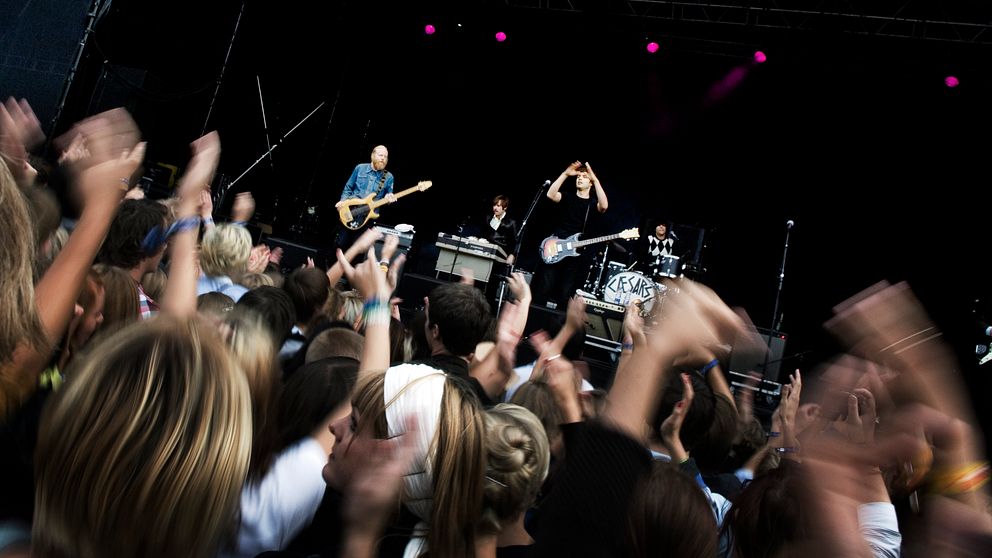 Publik som dansar framför en scen vid en konsert.