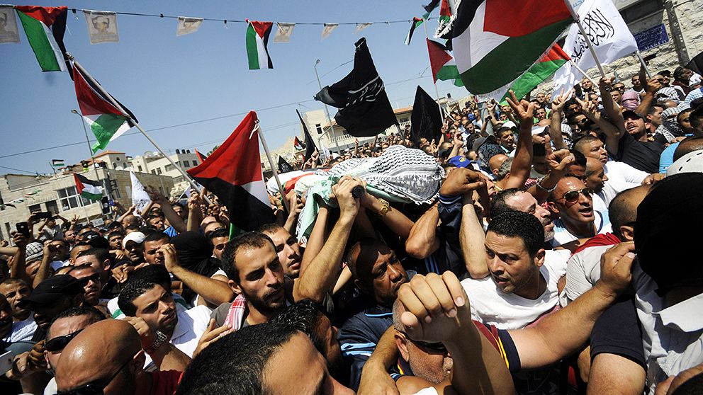 Palestinier bär den 16-årige pojkens kropp i Jerusalem.