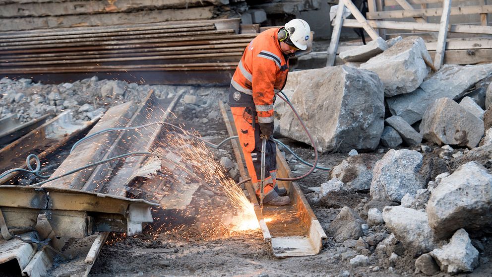 En byggarbetare med skärbrännare arbetar vid ombyggnaden av Slussen i Stockholm.