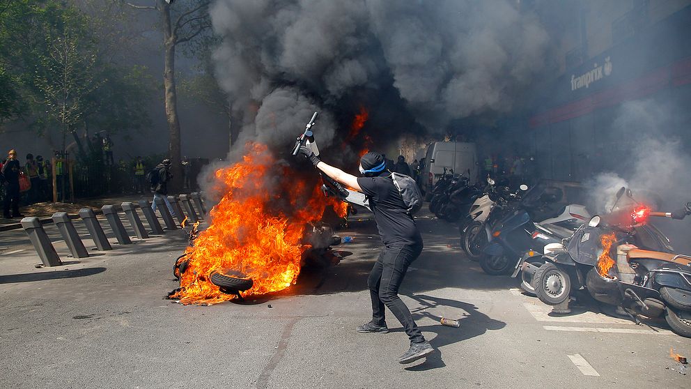 En demonstrant vid ett moln av röd och eld.