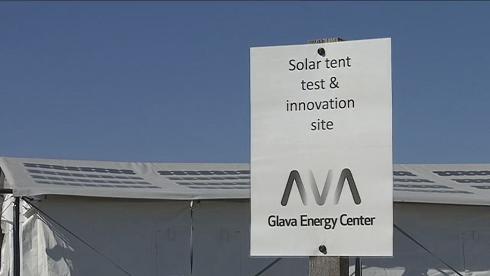 Vit skylt framför solcellstält med texten ”Solar tent test & innovation site”