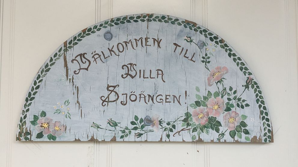 En skylt i trä där det står ”Välkommen till Villa Sjöängen”