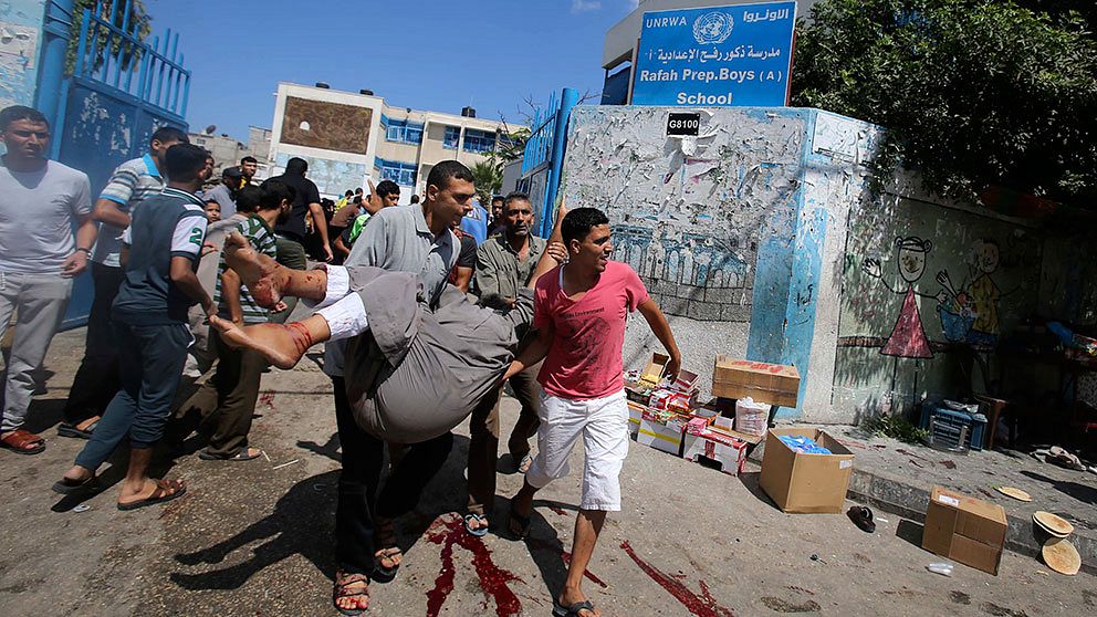 Skadade bärs bort efter attacken mot en FN-skola i Rafah