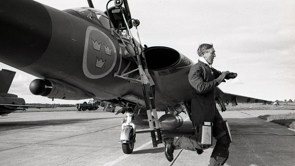 En pilot tittar på sin klocka och springer ifrån ett J35 Draken året är 1980