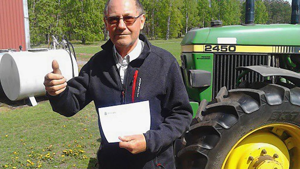 Kent Eriksson med brevet som visar att parkeringsboten och traktorn bakgrunden