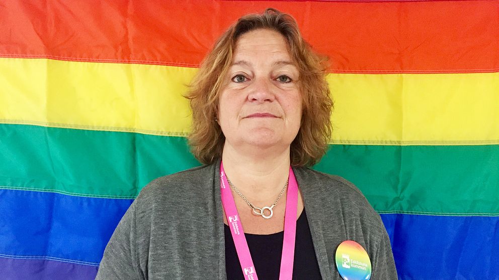 Helena Andersson Ssiamanis framför en stor pride-flagga.