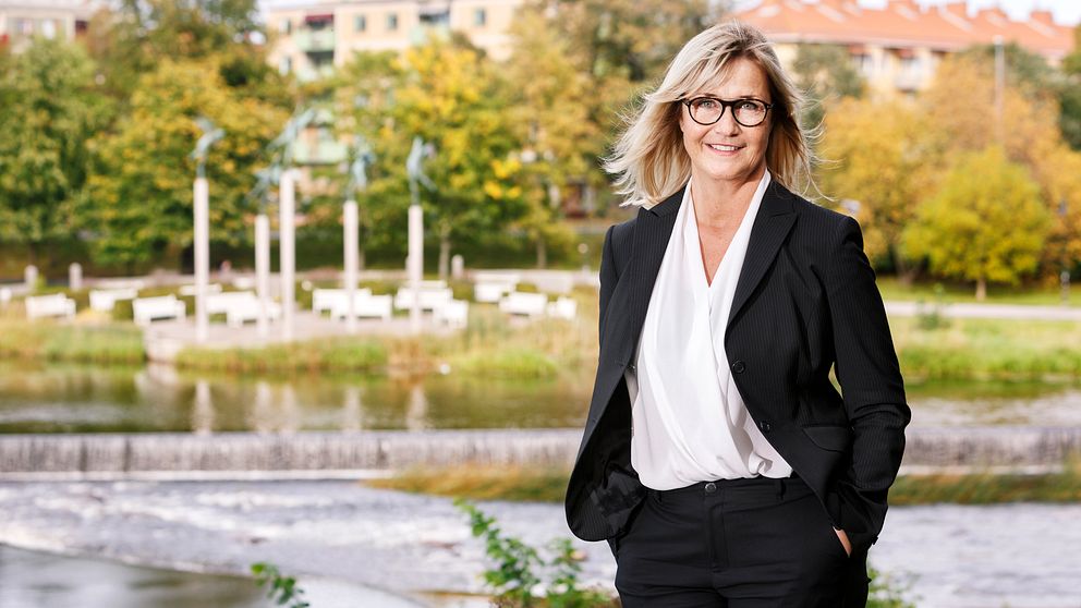 Porträttfoto på Folktandvården Gävleborgs vd, Ann-Christine Larsson Bolle. I bakgrunden syns gräs, träd och flera byggnader.