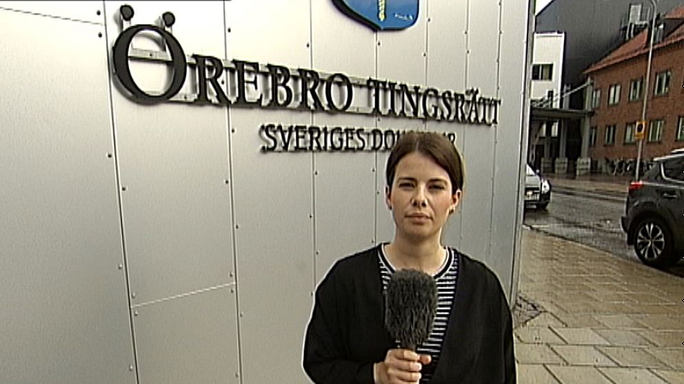 SVT:s reporter Emilie Pless framför skylten ”Örebro tingsrätt”