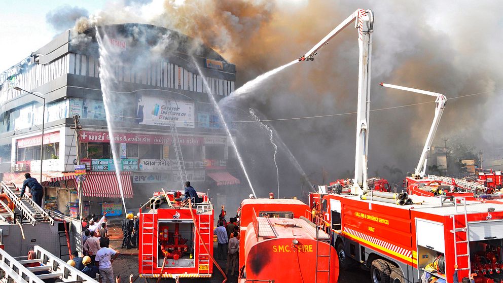 Flera brandbilar sprutar vatten på den brinnande byggnaden.