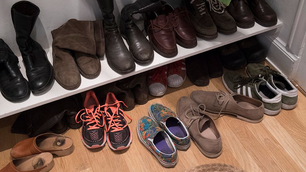 Skohylla med skor av olika sorter, exempelvis stövlar av läder, träskor och gymnastikskor.