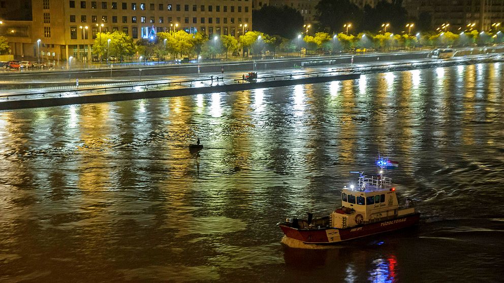 En räddningsbåt från den ungerska brandkåren letar efter överlevande i vattnet.