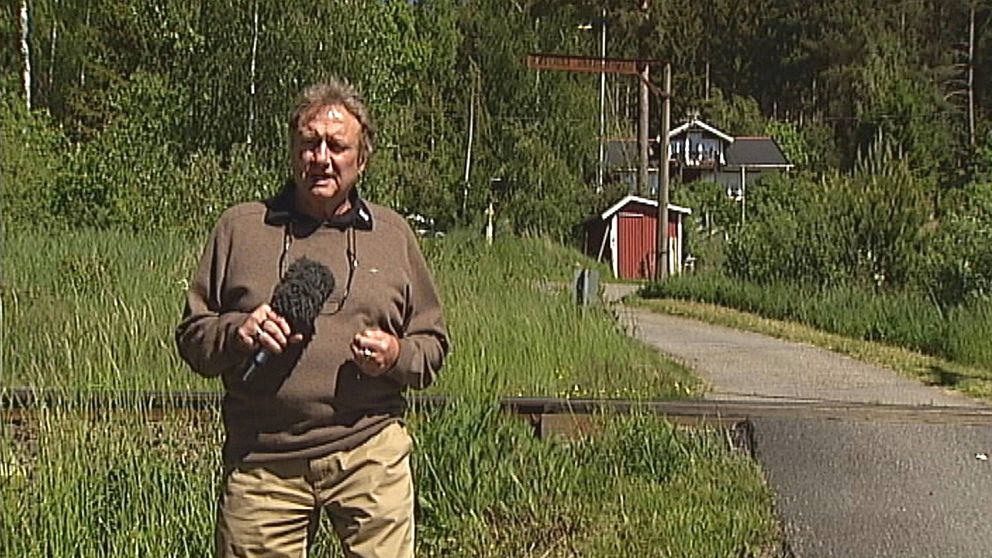 Reporter Kjell Lundström står framför en obevakad järnvägsövergång