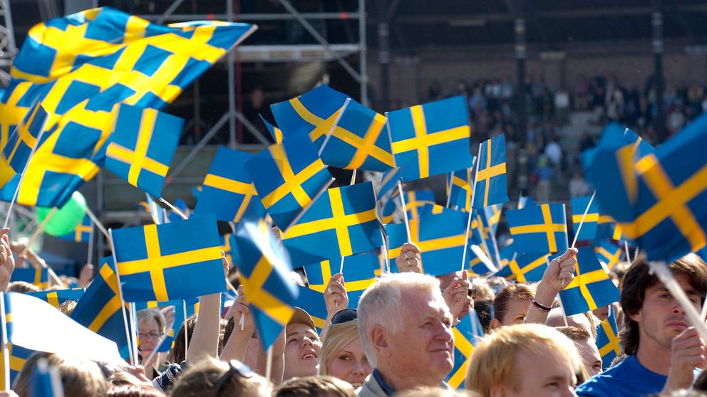 Människor viftar svenska flaggan.