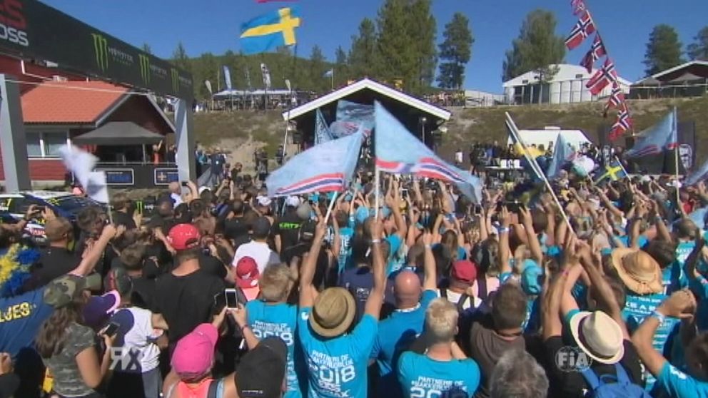 Folk firar med flaggor på rallycorss-tävling