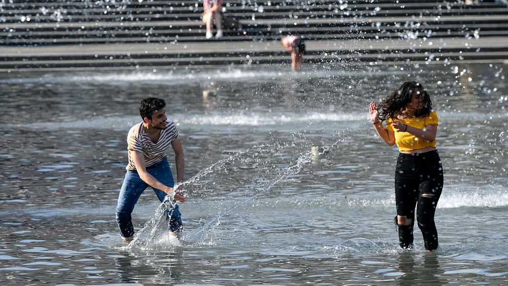 Ungdomar svalkar sig i fontänen i Kungsträdgården i Stockholm i det varma vädret.