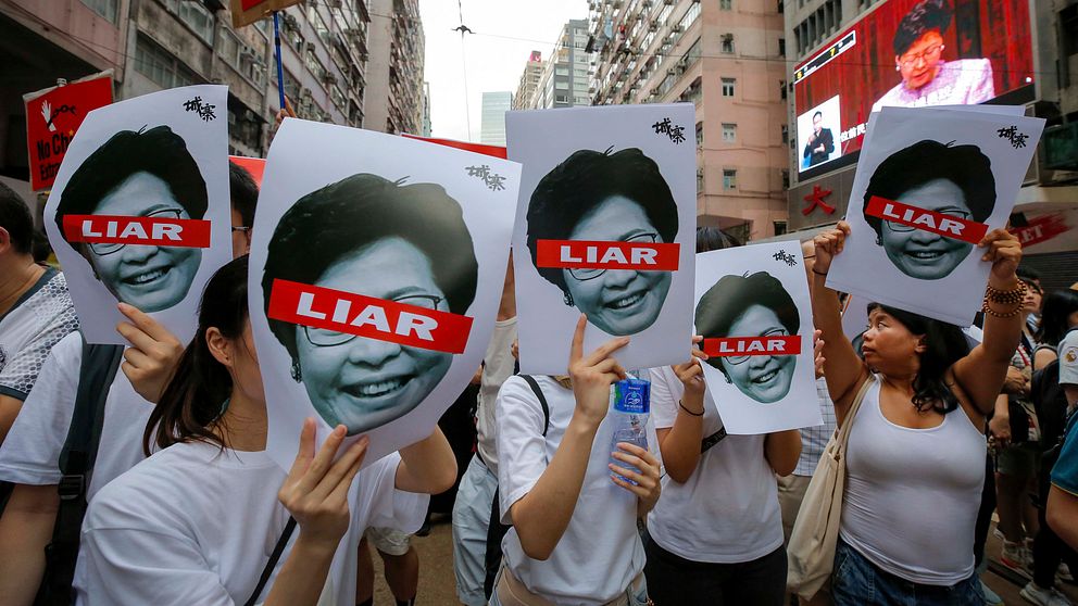 Demonstranter med plakat föreställande Hongkongs ledare Carrie Lam under söndagens protester.