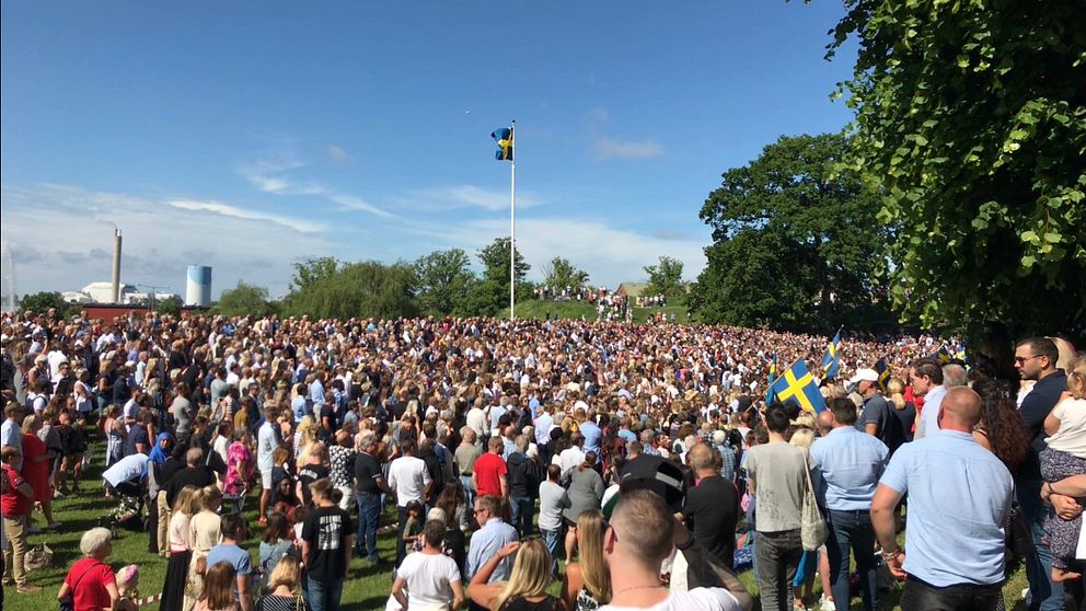 Skolavslutning i Nyköping. På Vallarna vid Nyköpingshus. Skolelever. Svenska flaggan och blå himmel.