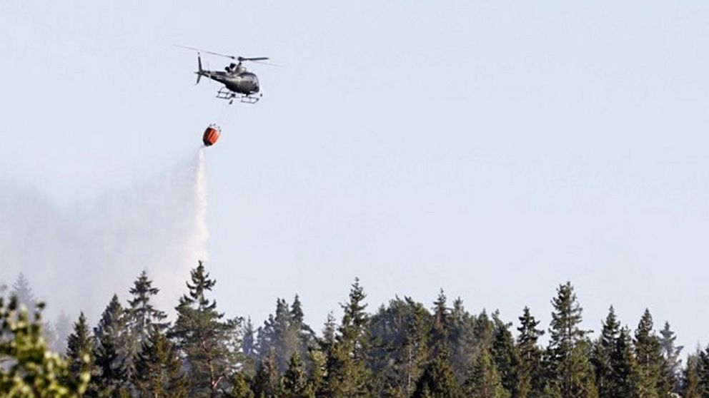 Helikopter som vattenbombar brand.