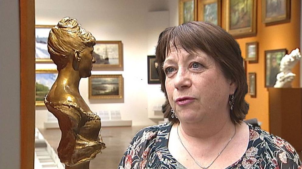 en medelålders kvinna som intervjuas inne på museum