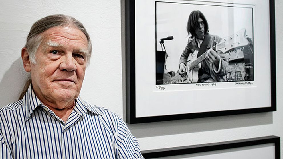Henry Diltz framför ett fotografi av Neil Young.