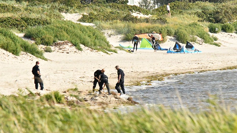 Poliser undersöker det misstänkta objektet på stranden i Lomma, som visade sig vara en gammal militär granat.