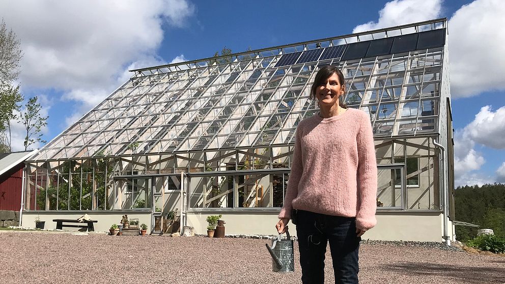 Susanne Andersson framför sitt hus i Havredal. På taket syns solpanelerna och solcellerna.