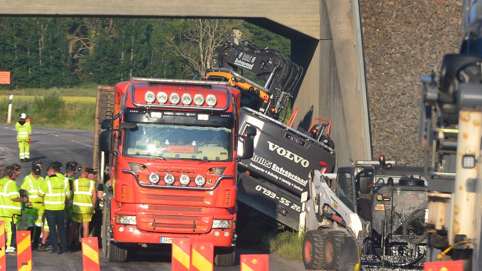 Lastbilen med grävmaskinen vid sidan av