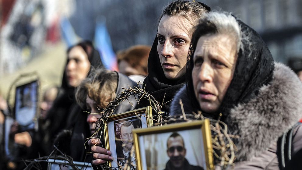 Kvinnor håller upp bilder på de som dött i sammandrabbningar med ukrainsk polis. Amnesty menar att båda sidor i konflikten gjort sig skyldiga till krigsbrott.
