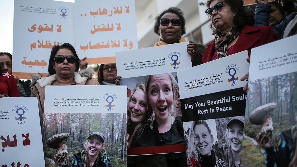 Marockanska kvinnor som håller upp bilder på de två skandinaviska kvinnorna som mördades.