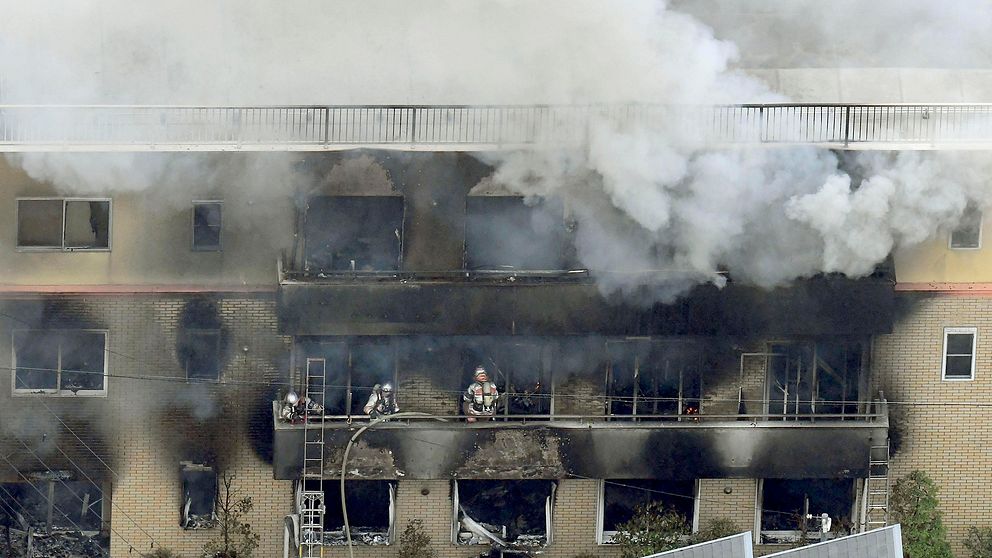 Brandmän som släcker branden i trevåningshuset där animestudion fanns i Kyoto, Japan.
