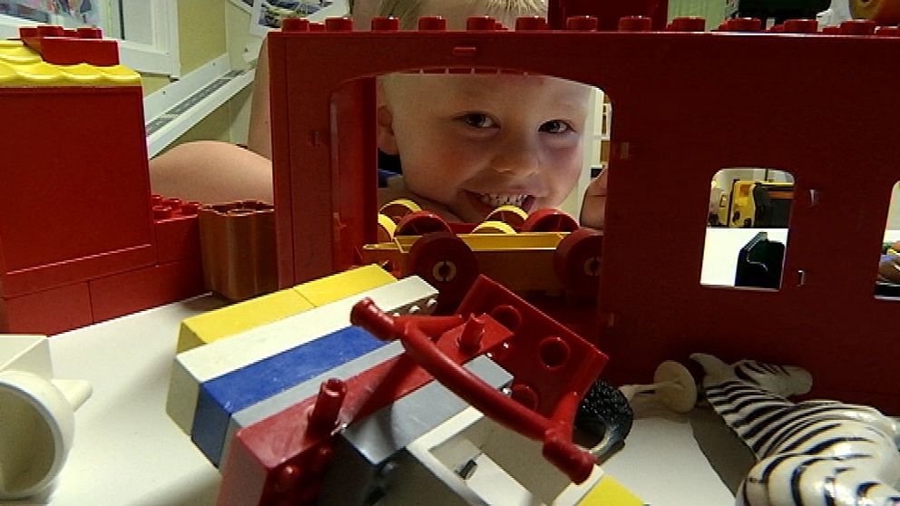 Lukas ler och kikar fram genom ett fönster i ett legohus.