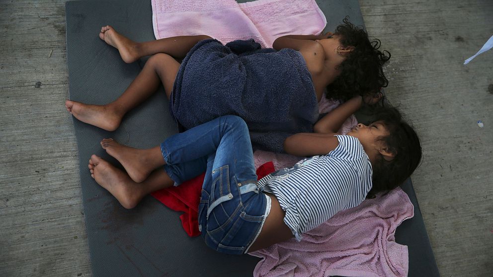 Två barn sover på en madrass vid ett migrantförvar vid den amerikanska gränsen.