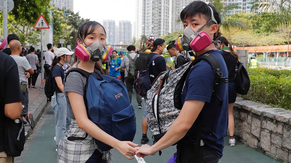 Ett par håller hand under en protest i Hongkong 5 augusti 2019.