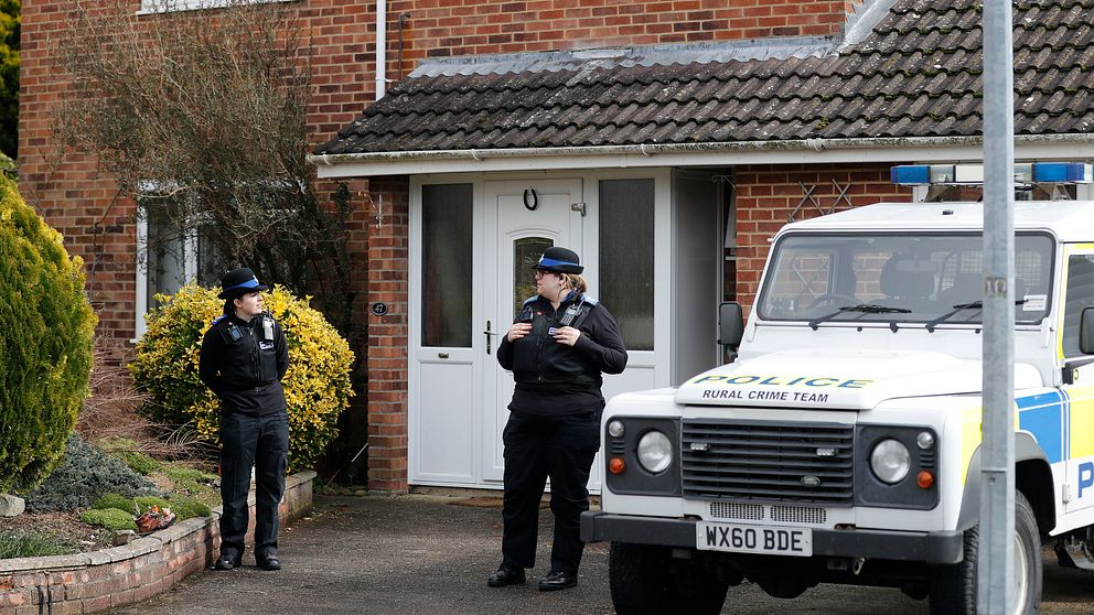 Brittiska poliser vid ett hus.