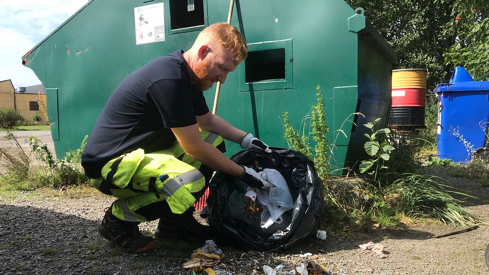 Miljöarbetaren Peter Callander städar upp på en återvinningsstation i Falkenberg.