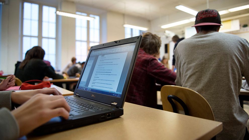 Elever i en skolsal, varaven med dator.