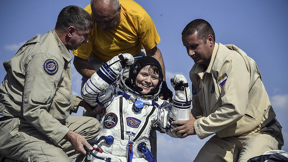 Anne McClain hjälps efter att ha återvänt från sin vistelse på ISS.