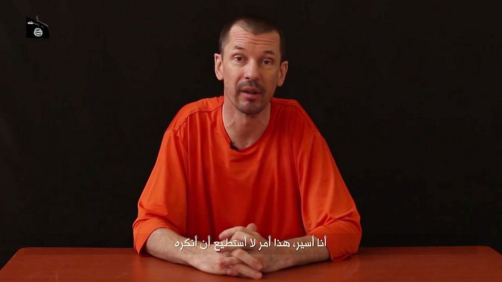 Den kidnappade journalisten John Cantlie säger att han ”ska berätta sanningen” om den Islamiska staten. Den arabiska textningen betyder ”jag är en fånge och det är något jag inte förnekar, skriver AP.