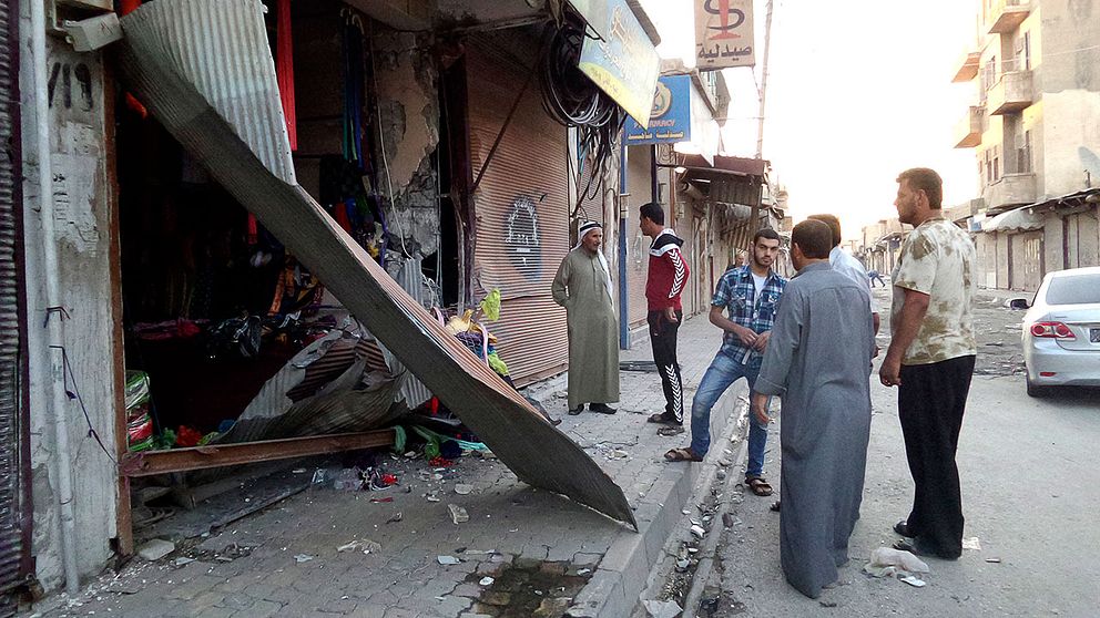 Folk inspekterar skadorna vid en butik i Raqqa i Syrien efter att en, enligt terrorgruppen Islamiska staten, amerikansk drönare slagit ner i en kommunikationscentral i närheten.
