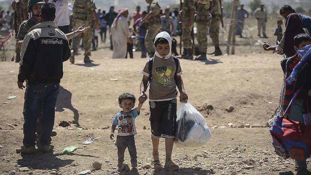 Syriska kurder flyr över gränsen till Turkiet efter hårda strider om staden Kobane, även kallad Ain al-Arab.