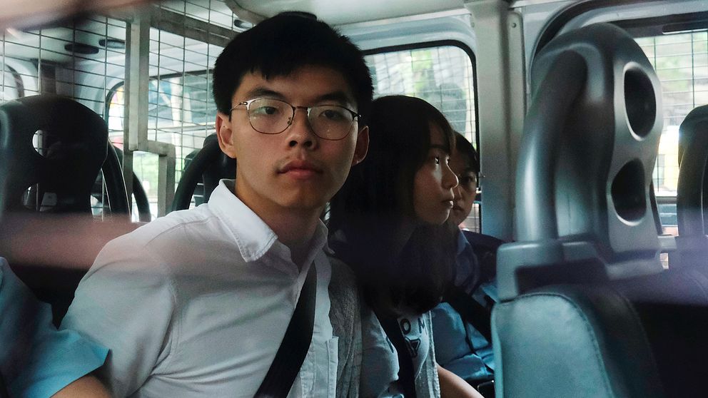 Aktivisterna Joshua Wong och Agnes Chow i en polisbil efter gripandet.