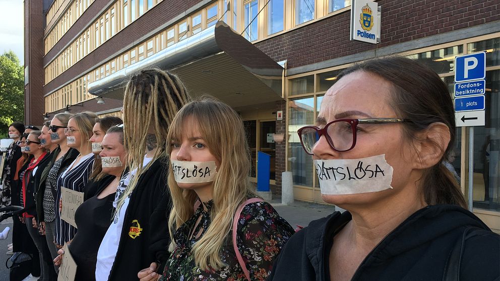 Kvinnor framför polishuset med tape för munnen. På tapen står det ”rättslösa”.