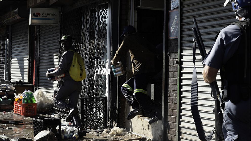 Plundrare som lyckas få med sig varor från en butik i Germiston öster om Johannesburg samtidigt som den sydafrikanska polisen närmar sig.