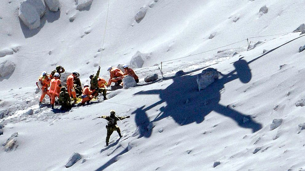 En skadad person hämtas med helikopter. Över 500 personer deltar i räddningsaktionen på vulkanen Ontake.