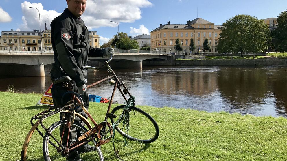 Krisofer Johannesson i Karlstads Dykarklubb står med en cykel som plockats upp ur Klarälven