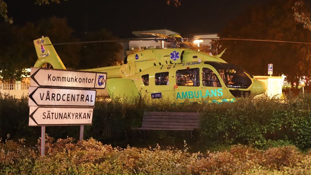Ambulanshelikopter bakom ett buskage.