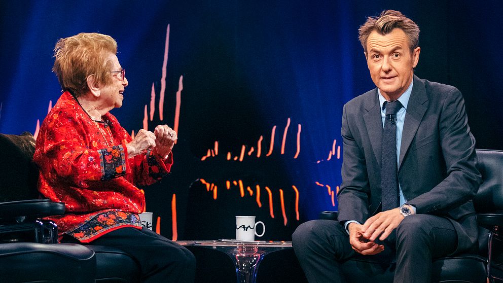 Fredrik Skavlan tittar förvånat in i kameran medan hans gäst i studion, Dr Ruth, ler.