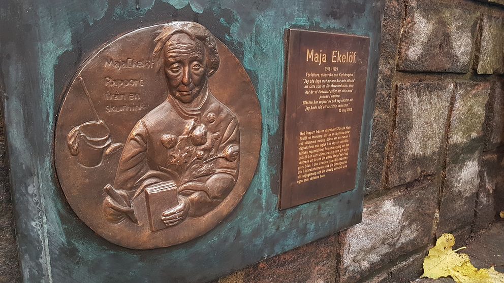 Minnesplakett över Maja Ekelöf sitter på en mur utanför biblioteket i Karlskoga.
