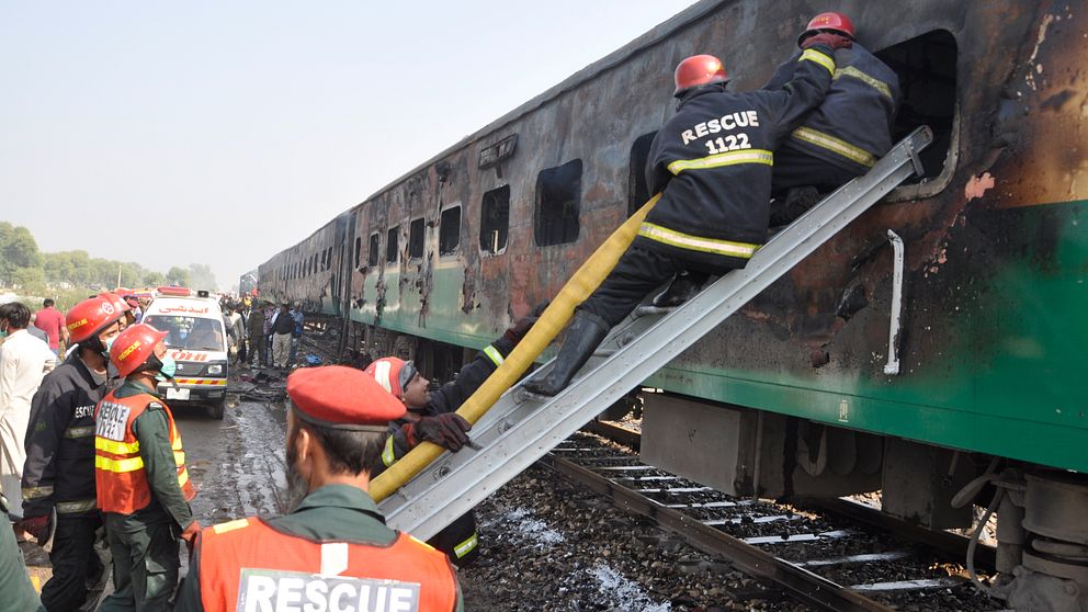 Hjälparbetare letar efter överlevare efter branden på tåget från Karachi till Rawalpindi  i Pakistan.
